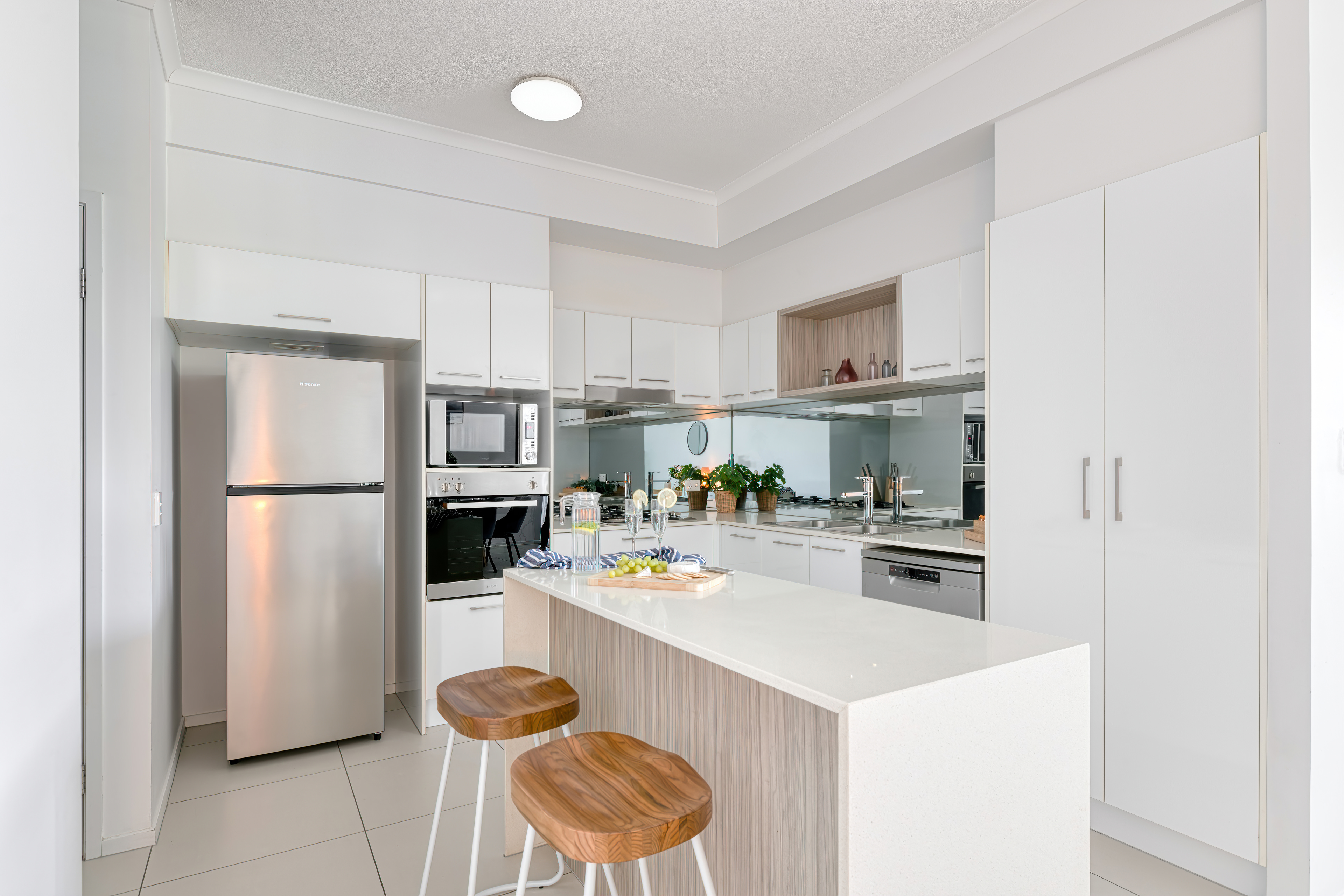 Full kitchen with mirror splashback and island bench